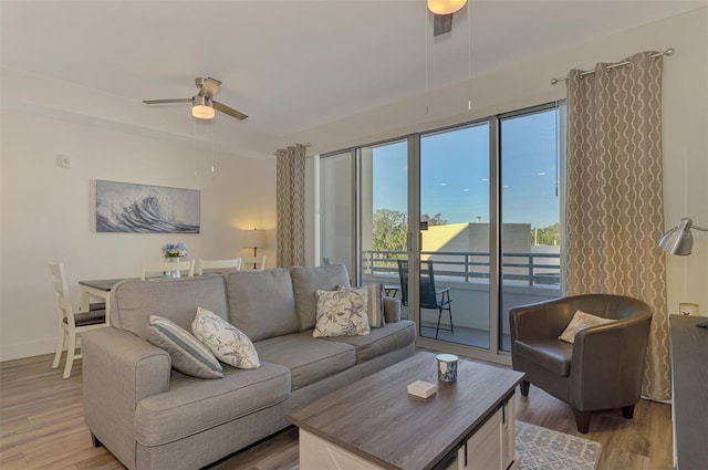 living room with ceiling fan and light wood-type flooring