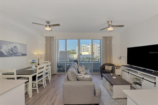 living room featuring ceiling fan and light wood-type flooring