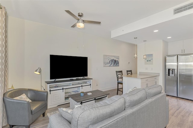 living room with ceiling fan and light hardwood / wood-style floors