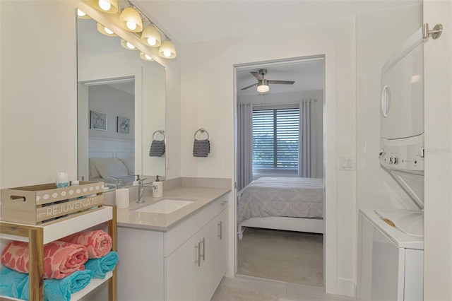 bathroom featuring ceiling fan, vanity, and stacked washer / drying machine