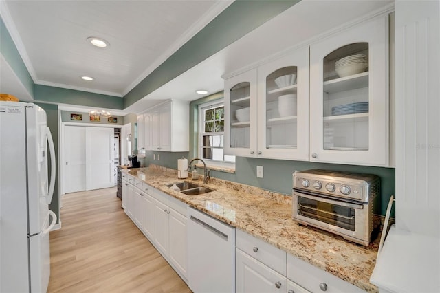 kitchen featuring sink, white cabinets, and white appliances