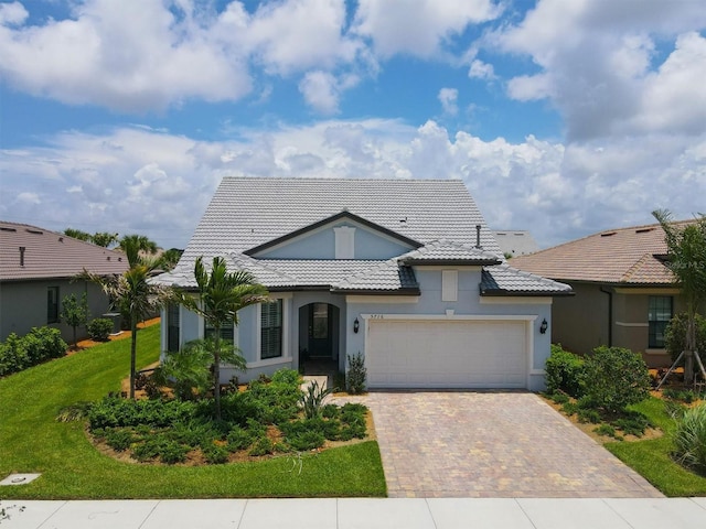 view of front of property featuring a front yard and a garage