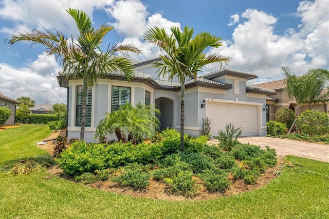 mediterranean / spanish-style house with a garage and a front lawn