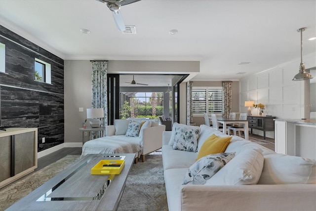 living room with hardwood / wood-style floors, ceiling fan, and ornamental molding