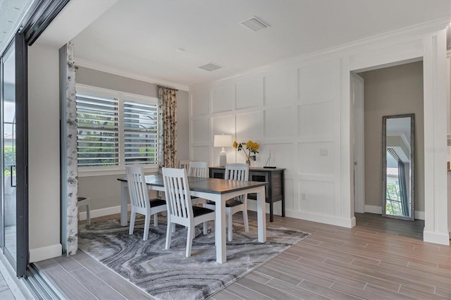 dining space with light hardwood / wood-style floors and crown molding