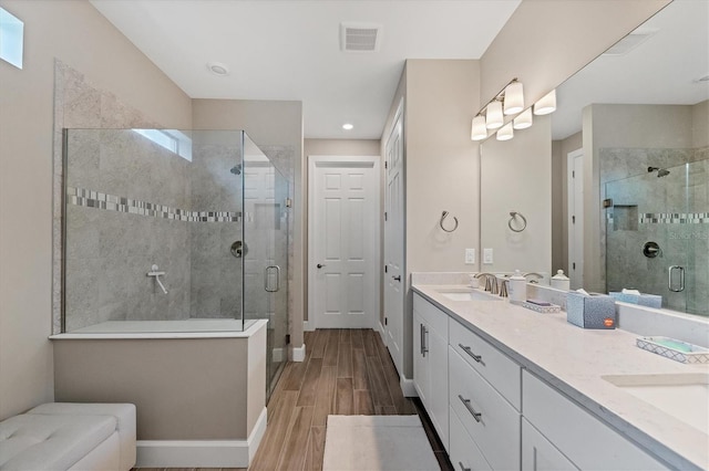 bathroom with vanity, an enclosed shower, and wood-type flooring