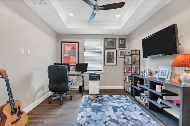 office space with a tray ceiling, ceiling fan, dark hardwood / wood-style flooring, and crown molding