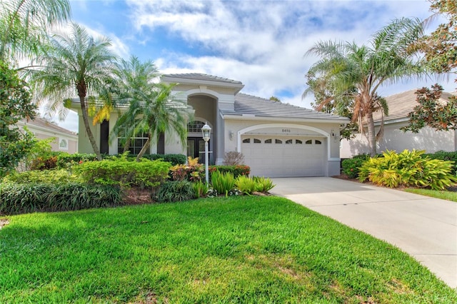 mediterranean / spanish-style house with a front yard and a garage