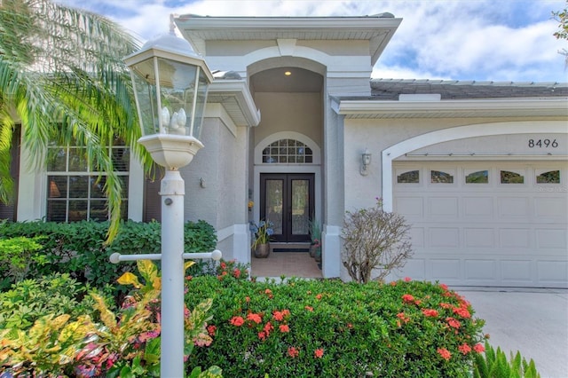 property entrance featuring a garage and french doors