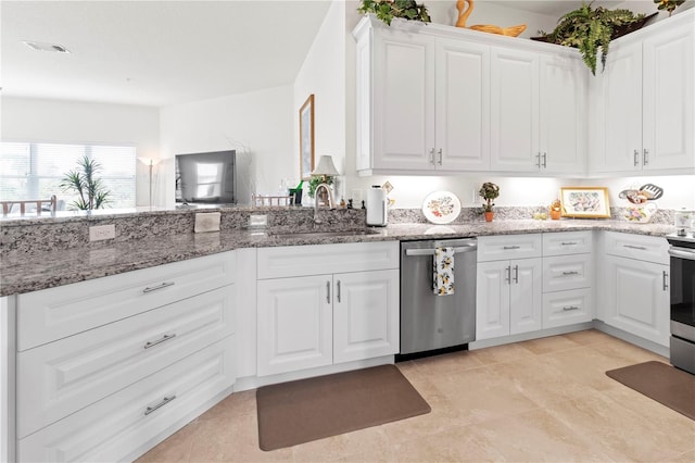 kitchen with sink, white cabinets, stainless steel appliances, and stone countertops