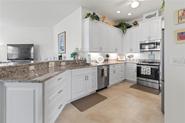 kitchen featuring white cabinets, dark stone countertops, sink, and appliances with stainless steel finishes