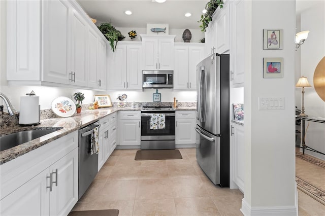 kitchen featuring light stone counters, white cabinetry, sink, and appliances with stainless steel finishes