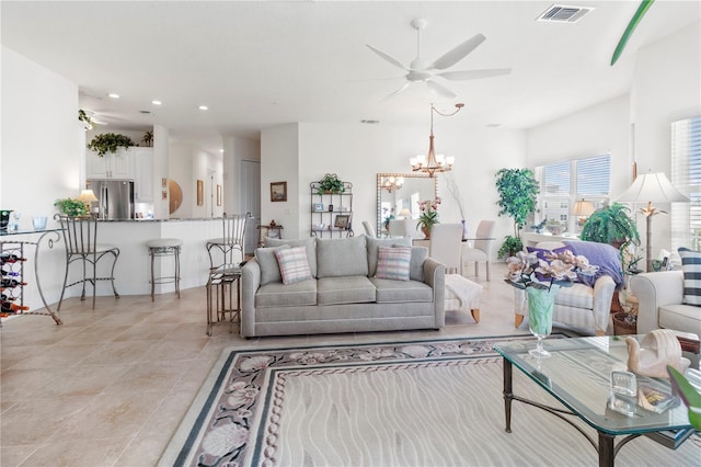 living room with ceiling fan with notable chandelier