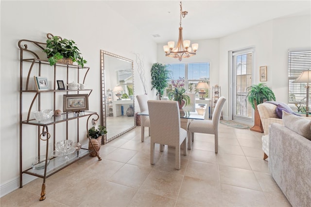 tiled dining room with a notable chandelier