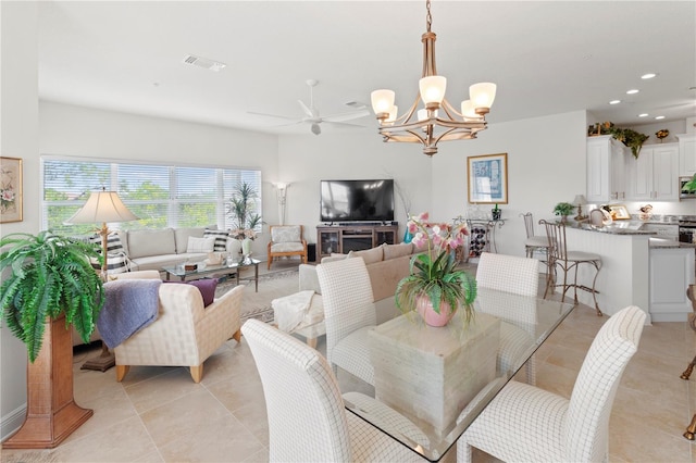 dining area with light tile patterned floors and ceiling fan with notable chandelier