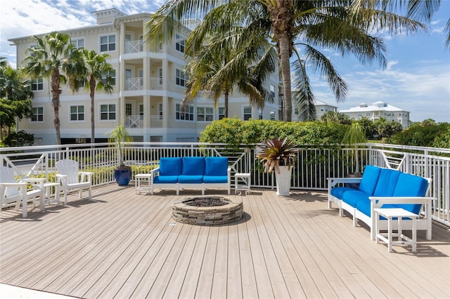 wooden deck featuring an outdoor living space with a fire pit