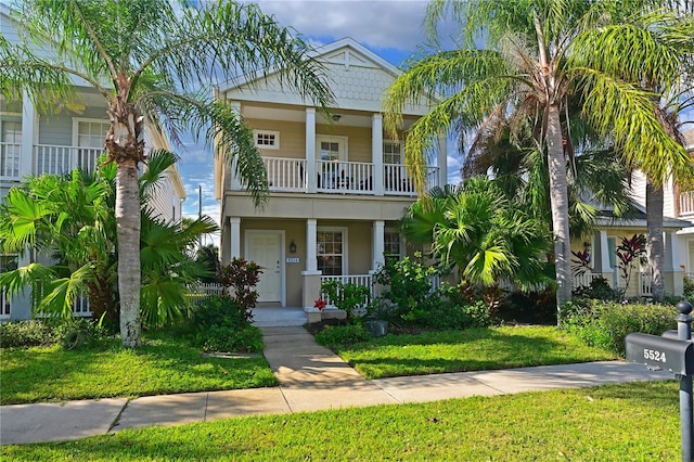 beach home with a front yard and a balcony