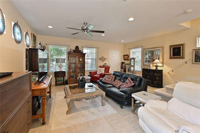 tiled living room with ceiling fan and a textured ceiling