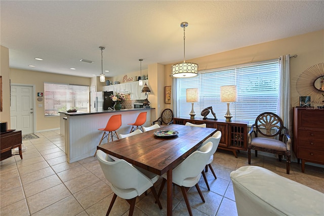 tiled dining space with a textured ceiling