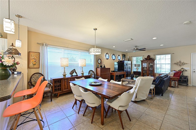 dining room featuring ceiling fan, light tile patterned floors, and a textured ceiling