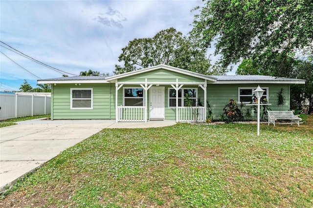 ranch-style house featuring a front lawn and covered porch