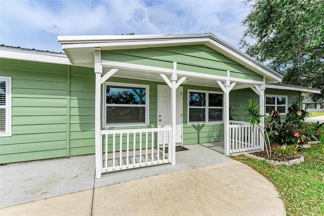 view of exterior entry featuring covered porch