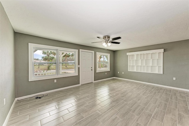 empty room featuring plenty of natural light and ceiling fan