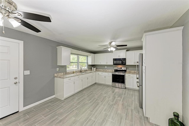 kitchen with sink, white cabinets, light hardwood / wood-style floors, and appliances with stainless steel finishes