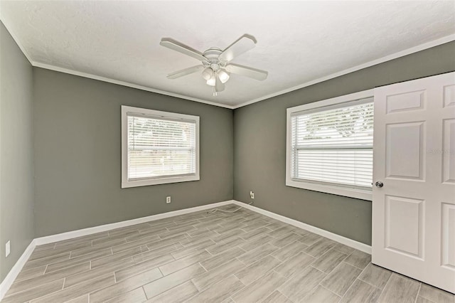 empty room with ceiling fan, crown molding, and a wealth of natural light