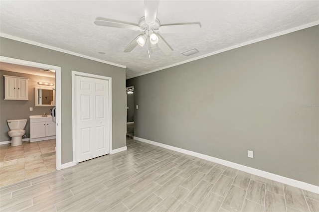 unfurnished bedroom with a textured ceiling, ensuite bath, ceiling fan, and ornamental molding