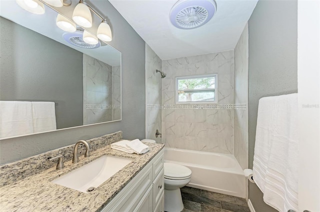 full bathroom with vanity, tiled shower / bath combo, and toilet