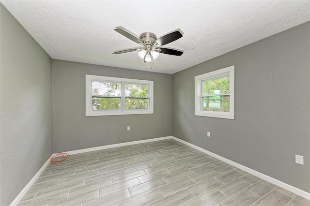 unfurnished room with ceiling fan, a healthy amount of sunlight, and a textured ceiling