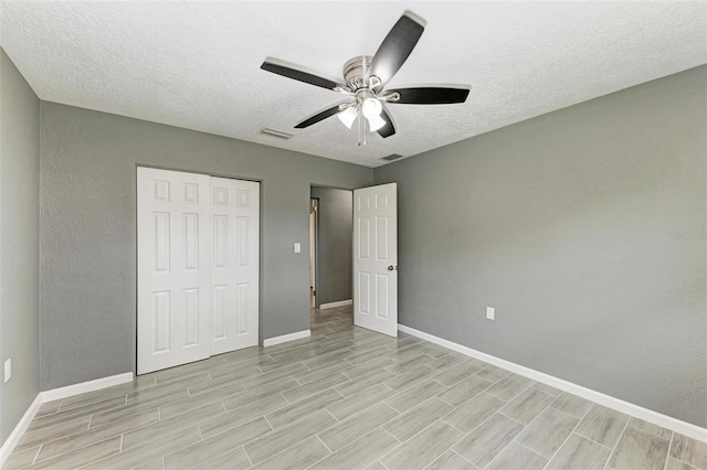 unfurnished bedroom with a closet, ceiling fan, light hardwood / wood-style flooring, and a textured ceiling