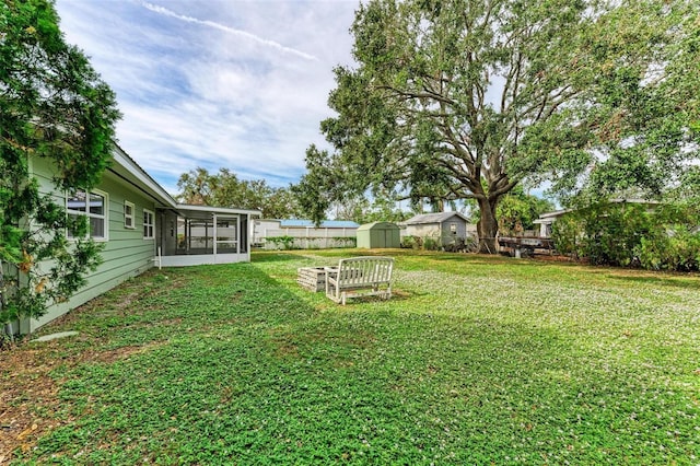 view of yard with a sunroom and a storage shed