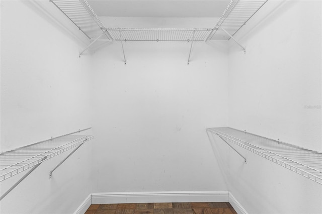 spacious closet featuring dark parquet floors