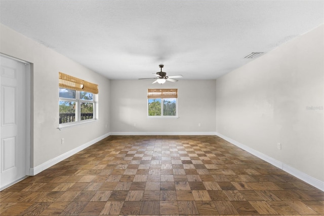 spare room with a textured ceiling and ceiling fan