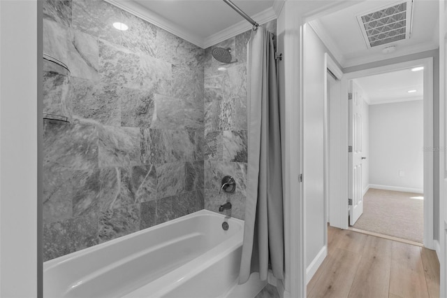 bathroom featuring crown molding, hardwood / wood-style floors, and shower / tub combo