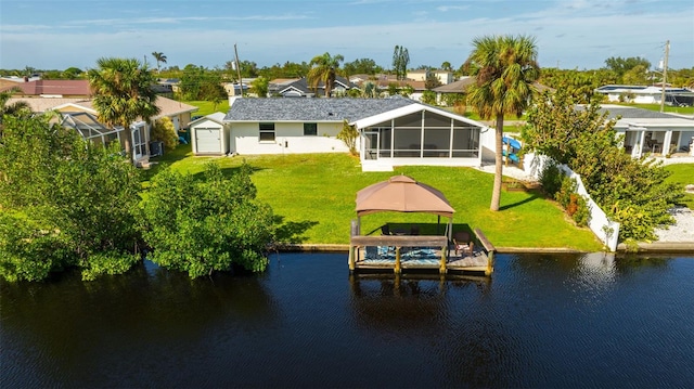 rear view of house with a gazebo, a water view, and a sunroom