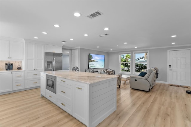 kitchen with white cabinets, stainless steel appliances, and light hardwood / wood-style flooring