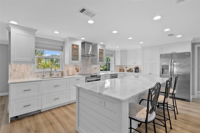 kitchen featuring appliances with stainless steel finishes, light hardwood / wood-style floors, a healthy amount of sunlight, and sink