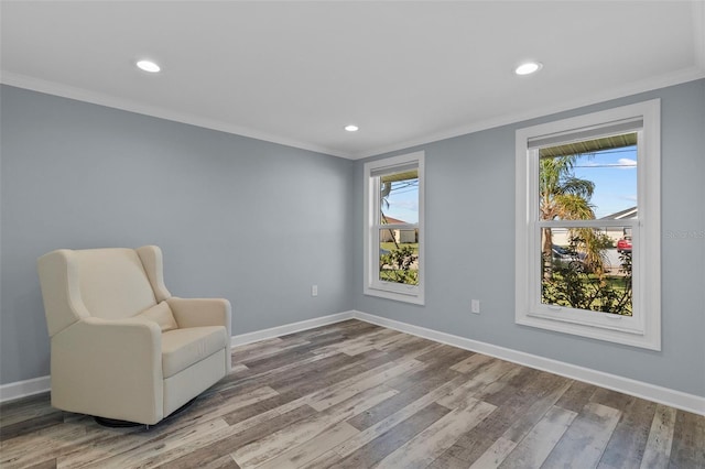 sitting room with wood-type flooring and ornamental molding