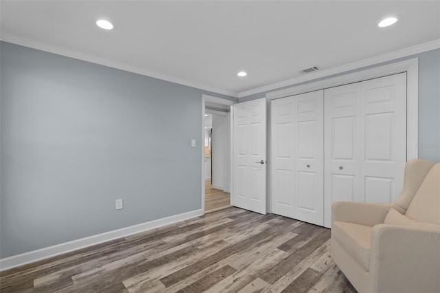 living area featuring wood-type flooring and crown molding