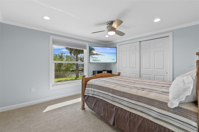 bedroom with ceiling fan, carpet floors, crown molding, and a closet