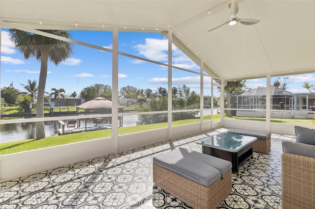 sunroom featuring a water view, vaulted ceiling, a wealth of natural light, and ceiling fan