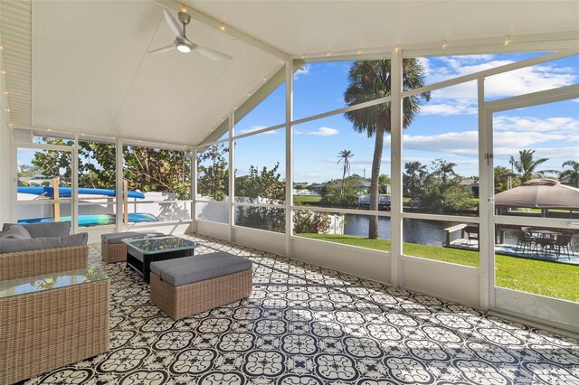 sunroom with vaulted ceiling with beams, ceiling fan, and a water view