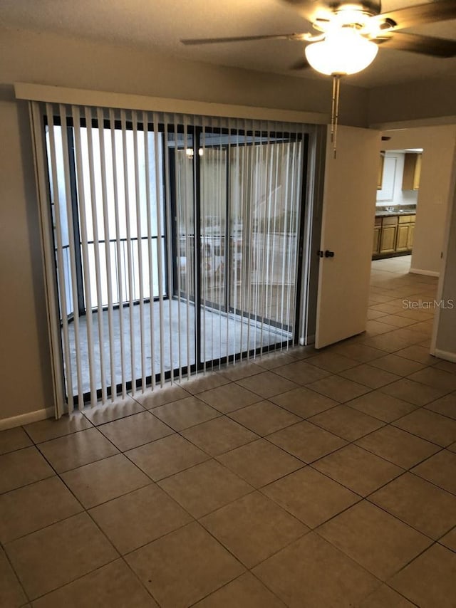 tiled empty room with ceiling fan