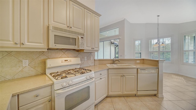 kitchen featuring light tile patterned floors, white appliances, a healthy amount of sunlight, and sink