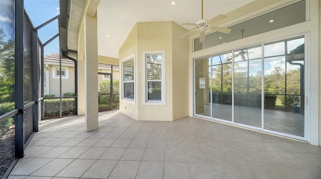 unfurnished sunroom with lofted ceiling, ceiling fan, and a healthy amount of sunlight