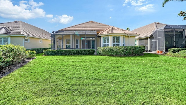 back of property featuring a lanai and a yard