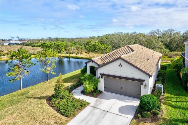 view of front of house featuring central AC unit, a garage, a water view, and a front lawn